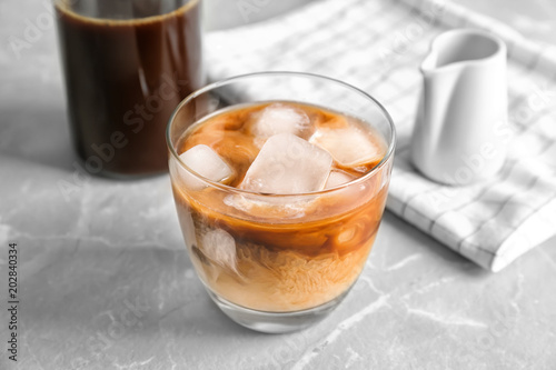 Glass with cold brew coffee and milk on light background