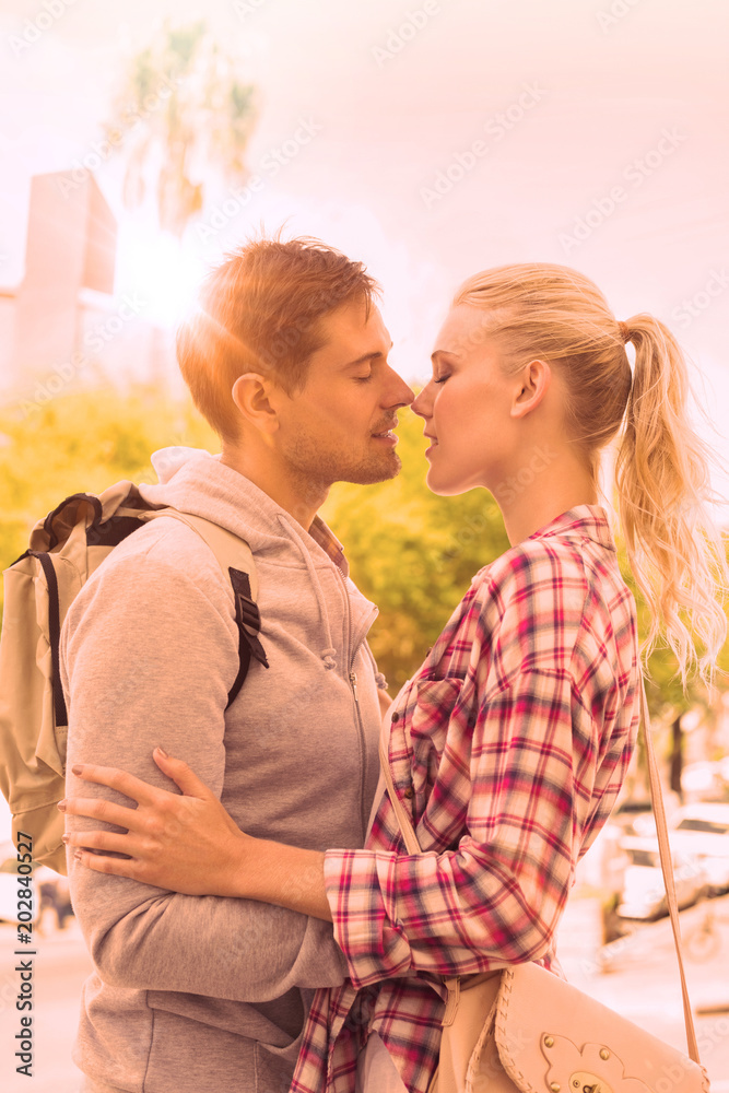 Young tourist couple about to kiss on a sunny day in the city Young tourist couple about to kiss on a sunny day in the city