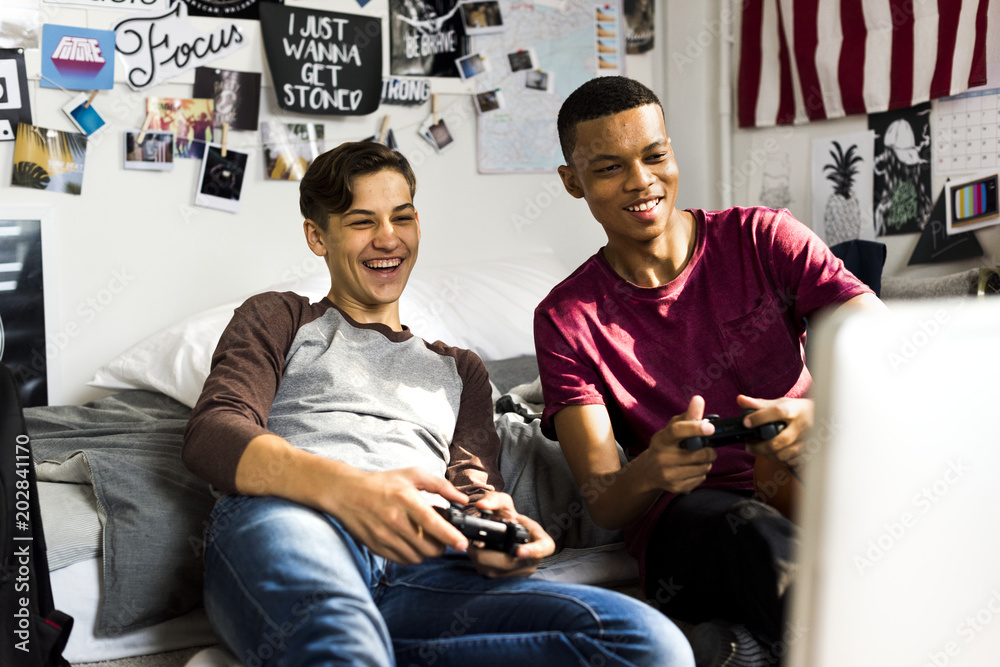Φωτογραφία Teenage boys hanging out in a bedroom playing video games together