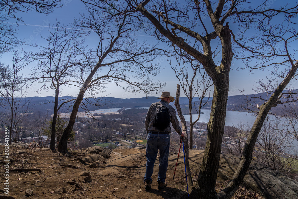 Man stoping on the hiking trail overlooking Hudson Valley at Bull Hill near Cold Spring NY