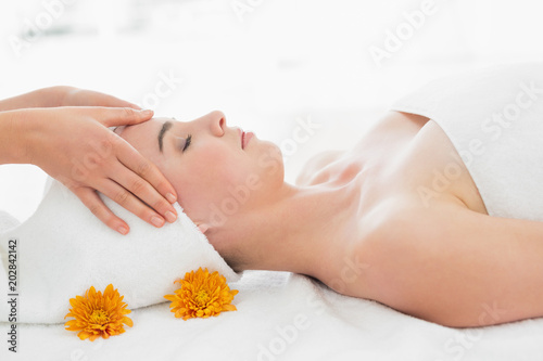 Hands massaging womans face at beauty spa