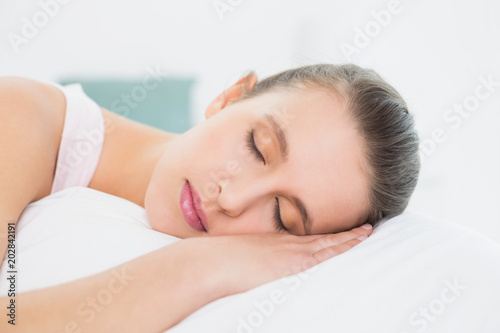 Pretty woman sleeping with eyes closed in bed