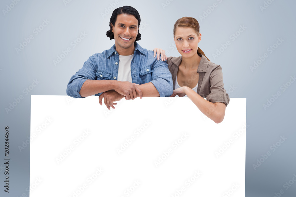 Couple leaning on blank wall against grey vignette Couple leaning on blank wall against grey vignette