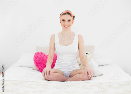 Young woman sitting on her bed