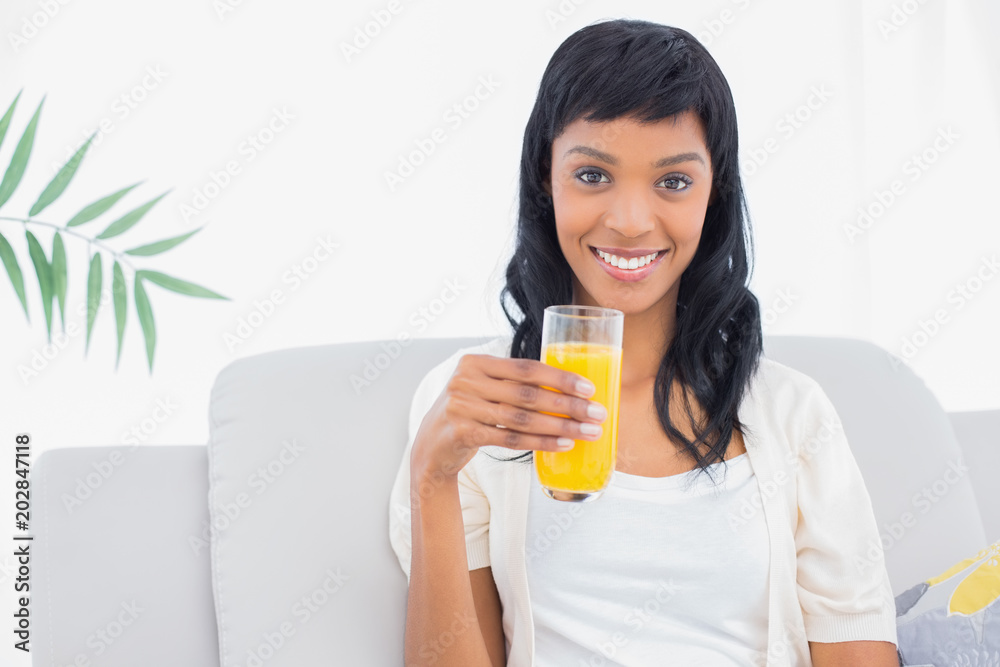 Lovely black haired woman in white clothes drinking orange juice Lovely black haired woman in white clothes drinking orange juice