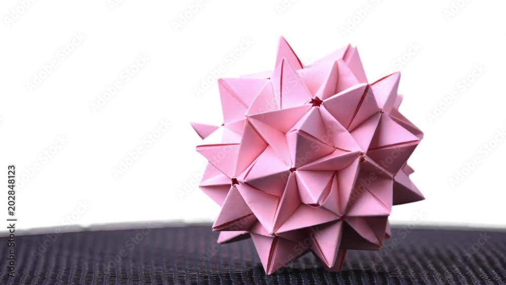 Stellated origami ball on white background. Spiky origami decoration isolated on white background. Modular cardboard product. Stellated origami ball on white background. Spiky origami decoration isolated on white background. Modular cardboard product.