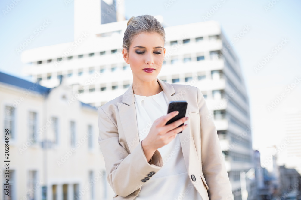 Peaceful attractive businesswoman sending a text message