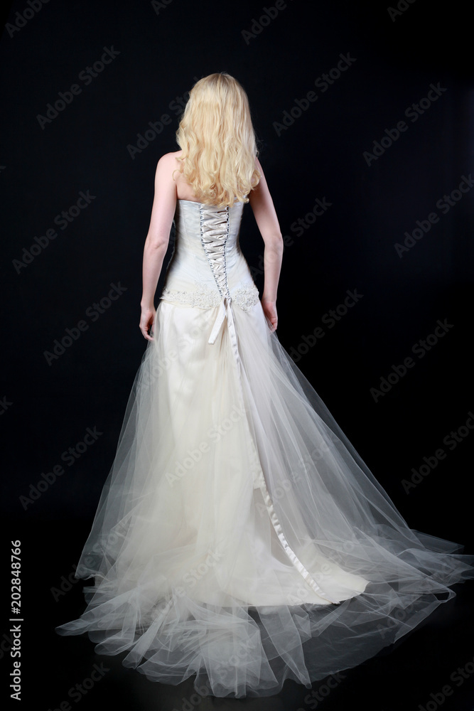 full length portrait of woman wearing white bridal gown. standing poison black studio background. full length portrait of woman wearing white bridal gown. standing poison black studio background.