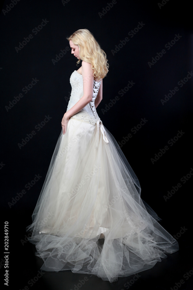 full length portrait of woman wearing white bridal gown. standing poison black studio background. full length portrait of woman wearing white bridal gown. standing poison black studio background.