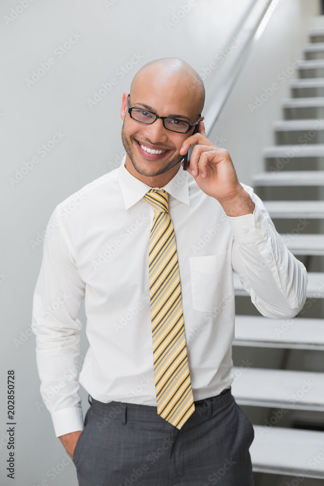 Smiling businessman using cellphone in office Smiling businessman using cellphone in office