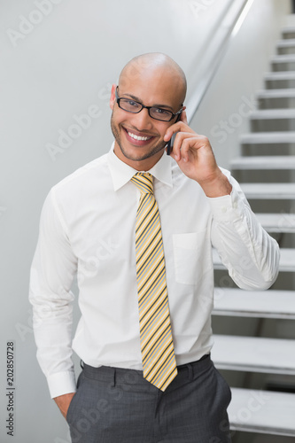 Smiling businessman using cellphone in office