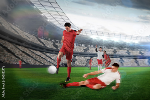 Football player in red kicking against large football stadium with lights © vectorfusionart