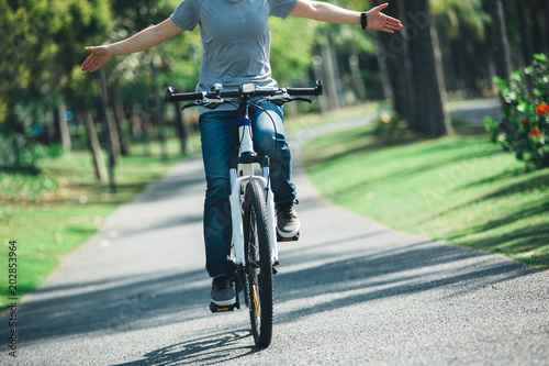 Fototapeta Naklejka Na Ścianę i Meble -  woman cyclist riding bike on tropical park