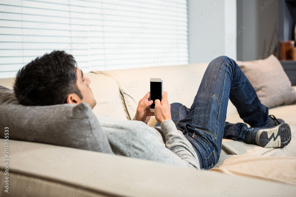 Over shoulder view of casual man using smartphone Over shoulder view of casual man using smartphone