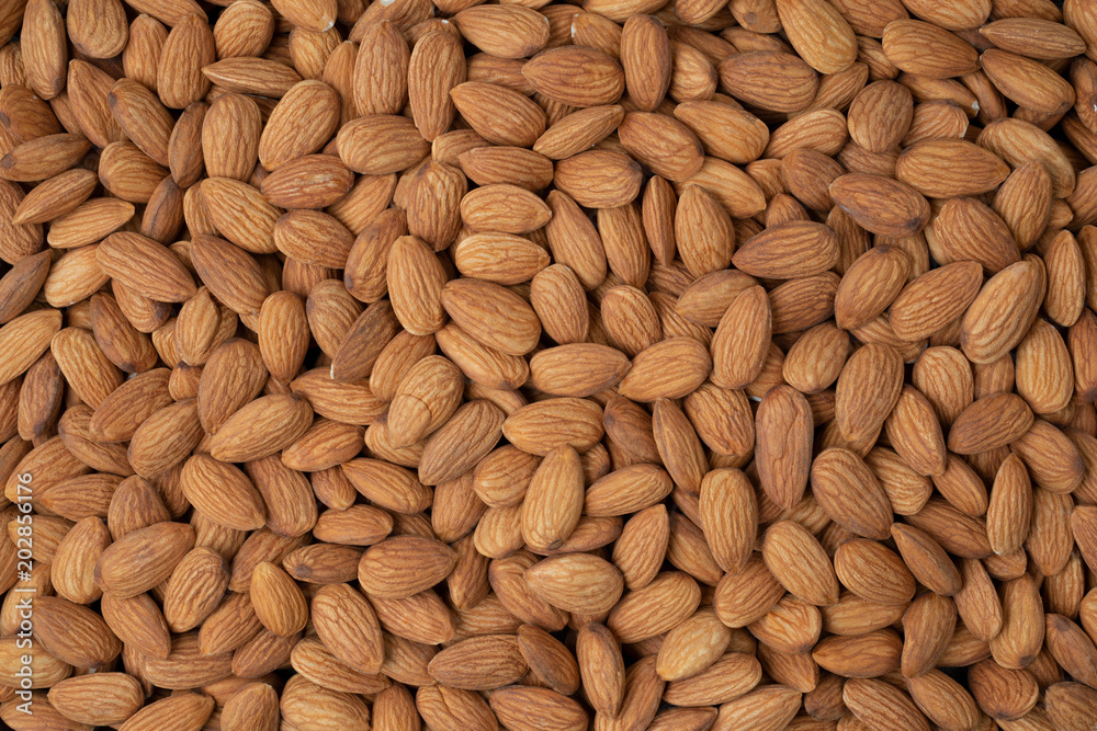Almond nuts pile background. Roasted peeled almond nuts pile texture ,top view. Almond nuts pile background. Roasted peeled almond nuts pile texture ,top view.