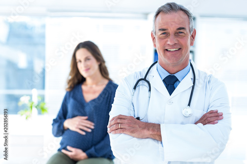 Canvas-taulu Portrait of smiling doctor with pregnant woman at clinic