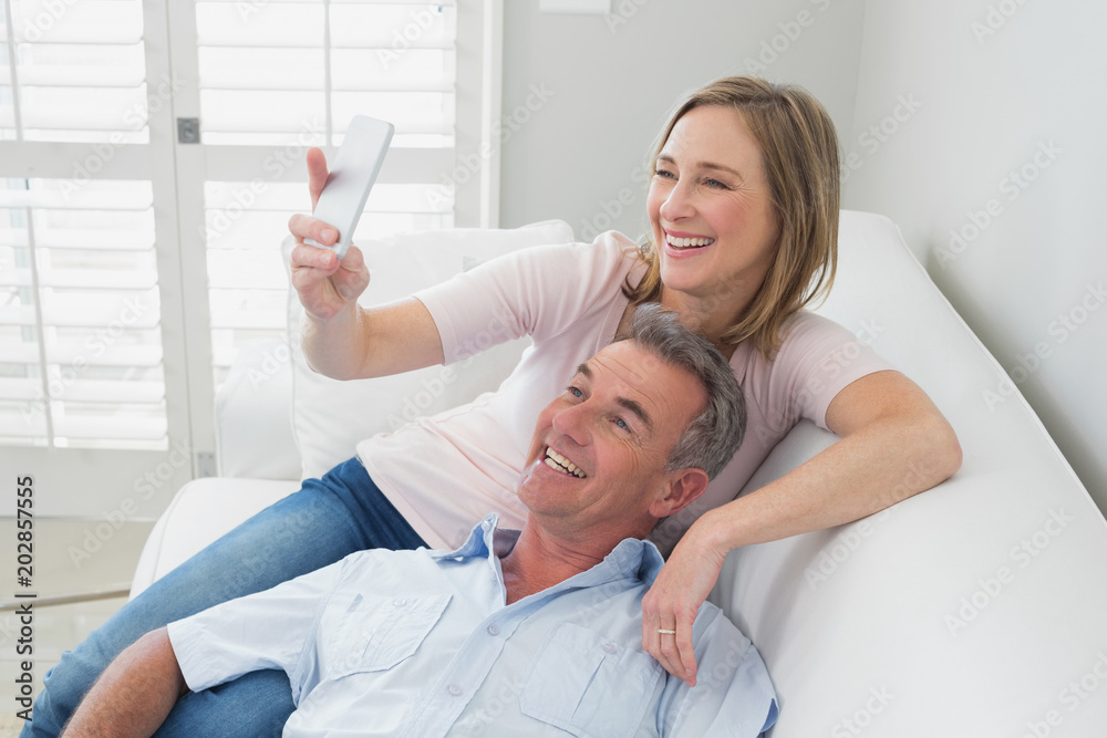 Obraz premium Couple clicking pictures with mobile phone at home