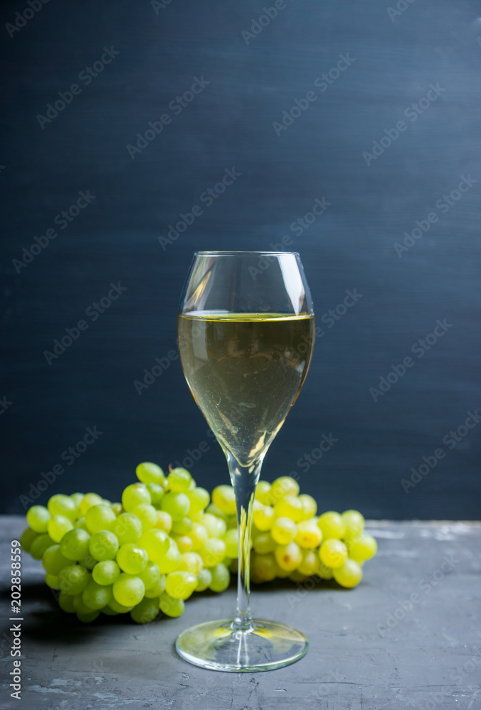 Glass of white wine with bunch of grapes. Selective focus. Shallow depth of field. Glass of white wine with bunch of grapes. Selective focus. Shallow depth of field.