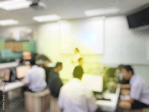 Blurred image of group of students are learning and sitting at desk using computer lap together in classroom for study and workshop in computers room at secondary school. education technology concept.