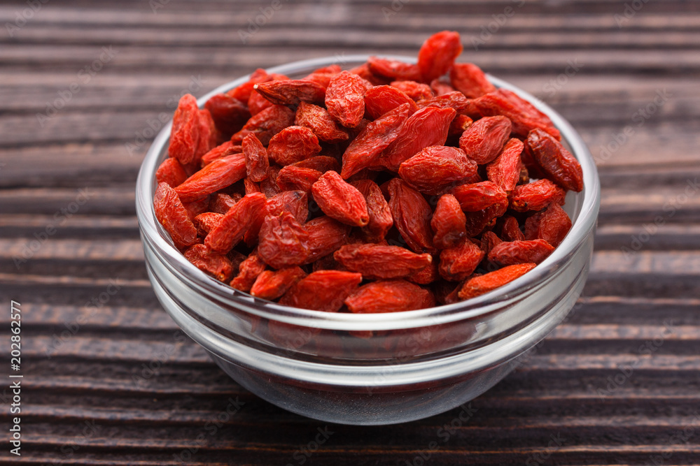 dried goji berries on a wooden rustic background dried goji berries on a wooden rustic background