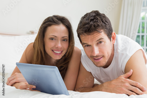 Couple using digital tablet in bed © WavebreakmediaMicro