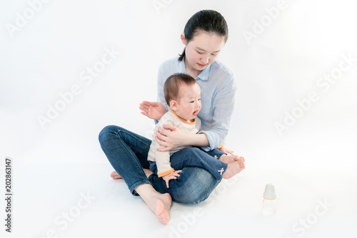 The baby and mother are playing, in the white background