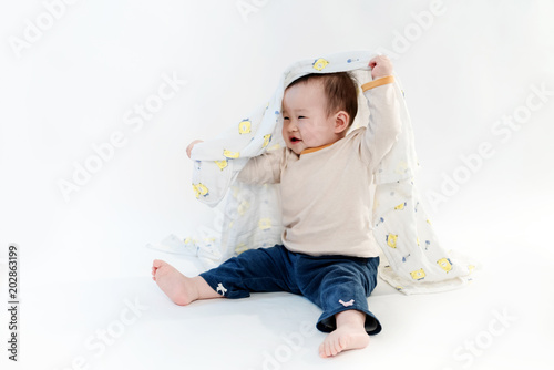 The baby is playing on the floor, the white background