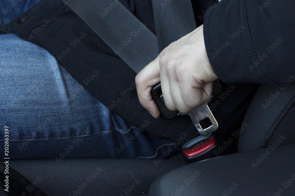 A man fastens his seat belt, close-up