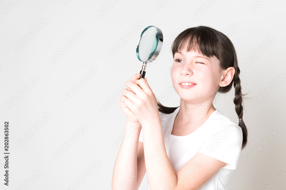 Pretty girl look at something through a magnifying glass. Pretty girl look at something through a magnifying glass.