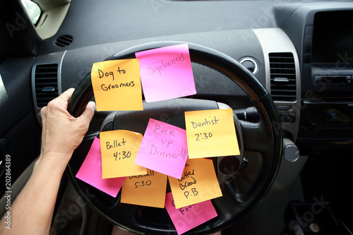 Steering wheel covered in notes as a reminder of errands to do photo