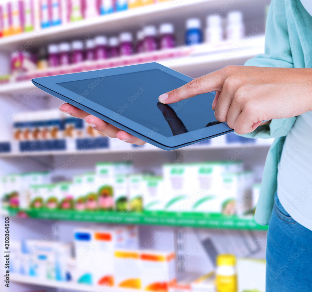 Woman using tablet pc against close up of shelves of drugs Woman using tablet pc against close up of shelves of drugs