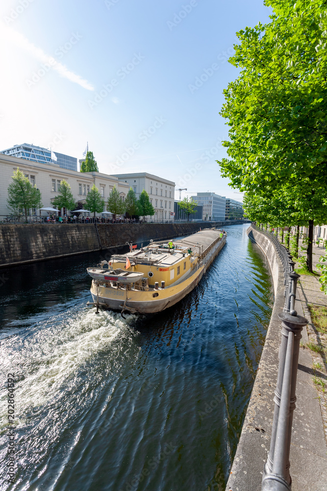 Cargo ship on a river through a city (Berlin)