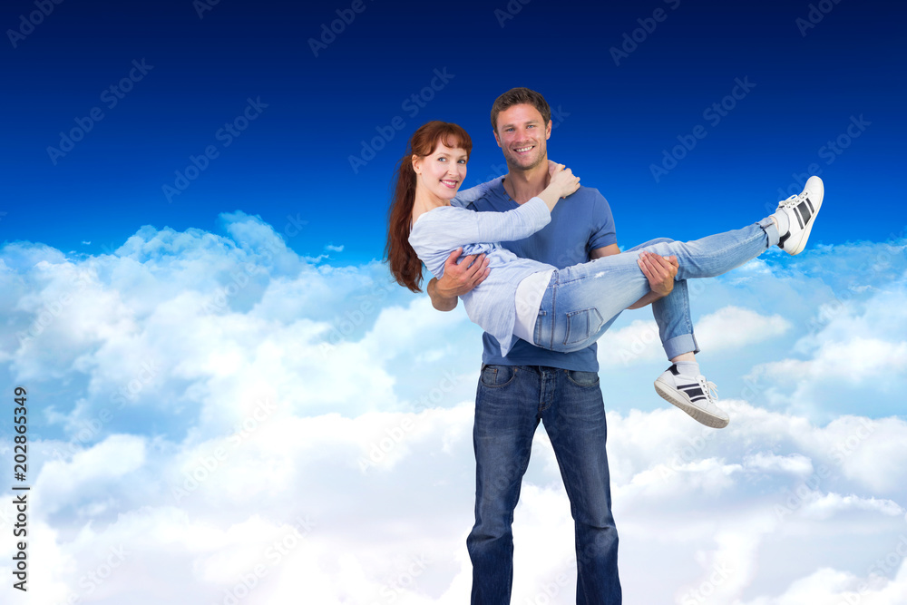 Man lifting up his girlfriend against bright blue sky over clouds Man lifting up his girlfriend against bright blue sky over clouds