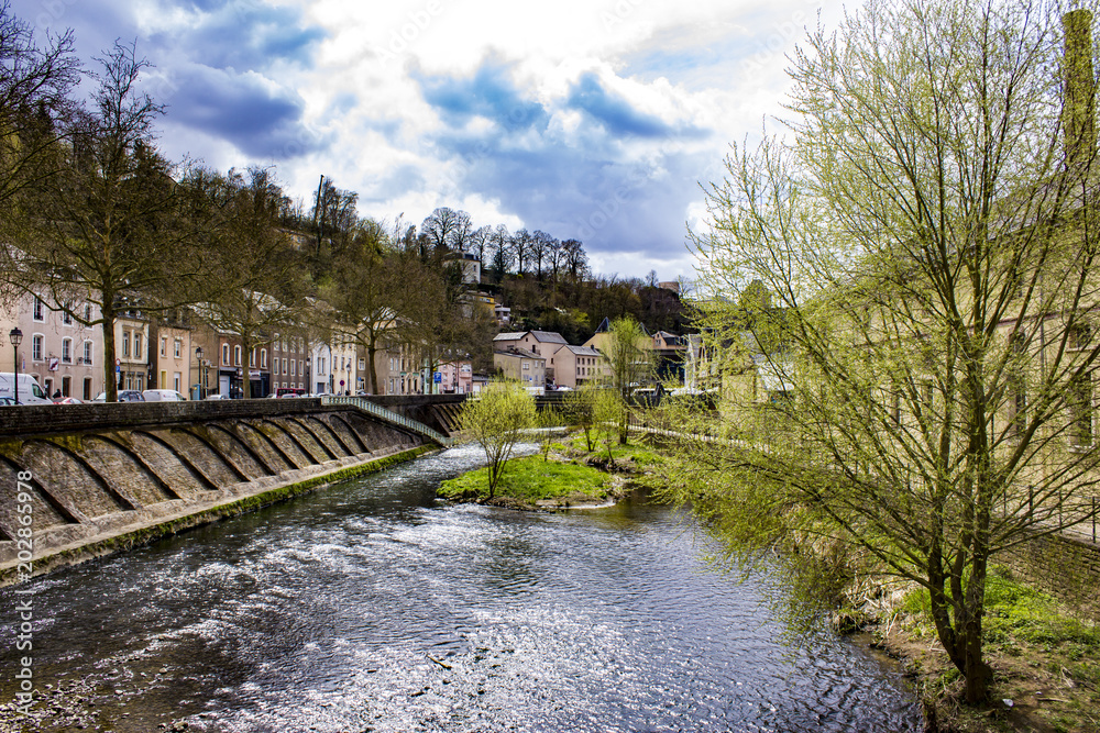 Looking Down the Alzette River with Spring Trees Blooming on Each Side in Luxembourg City, Luxembourg, Horizontal Orientation