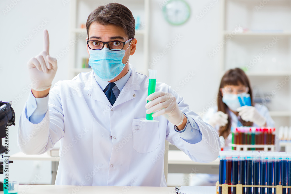 Two chemists working in lab experimenting Two chemists working in lab experimenting