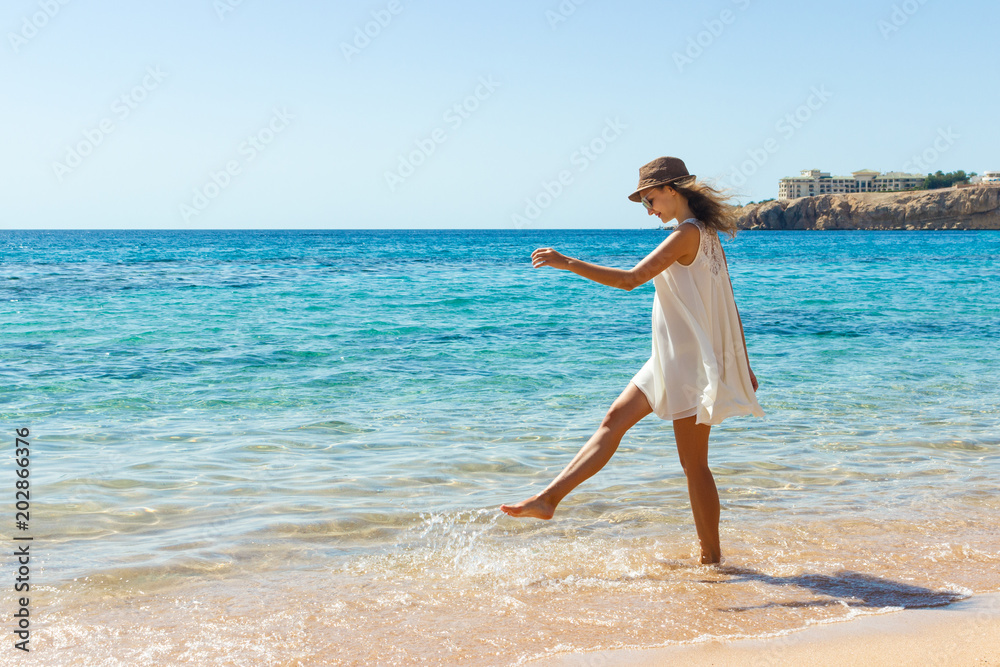 Woman relaxing at beach enjoying summer freedom. Happ girl at the beach Woman relaxing at beach enjoying summer freedom. Happ girl at the beach