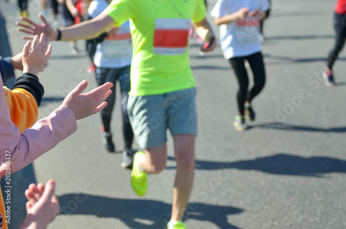 Marathon running race, support runners on road, child's hand giving highfive, sport concept 