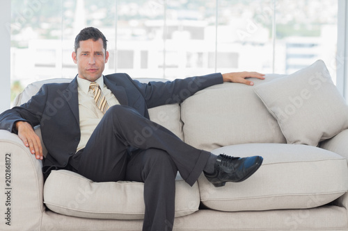 Serious businessman in suit posing sitting on sofa © WavebreakmediaMicro