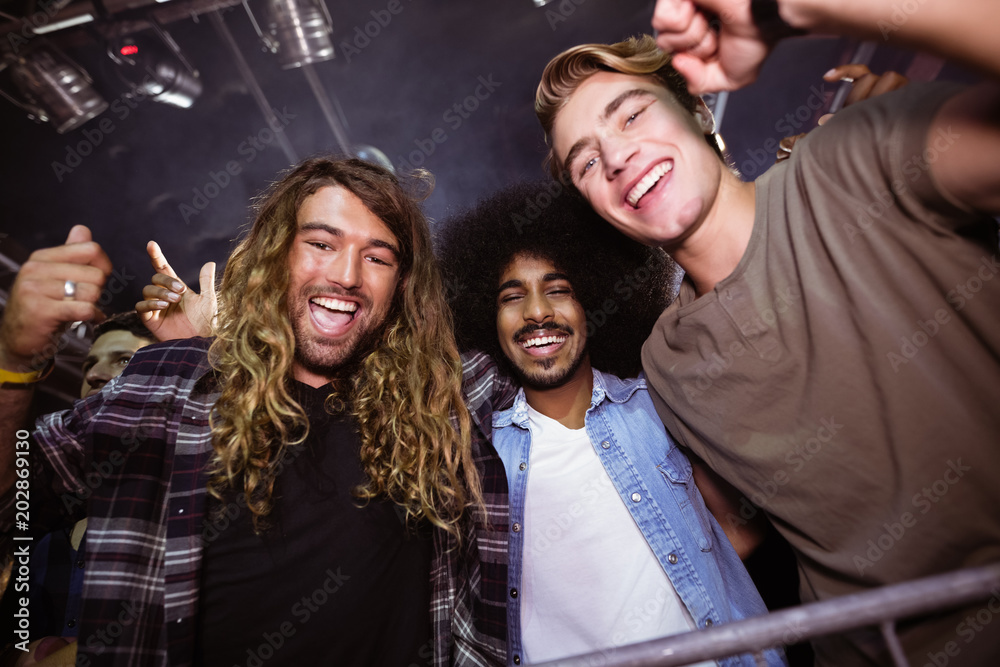 Male friends enjoying at nightclub during music festival Male friends enjoying at nightclub during music festival