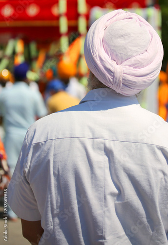 man with white shirt and big pink turban during the religious pa