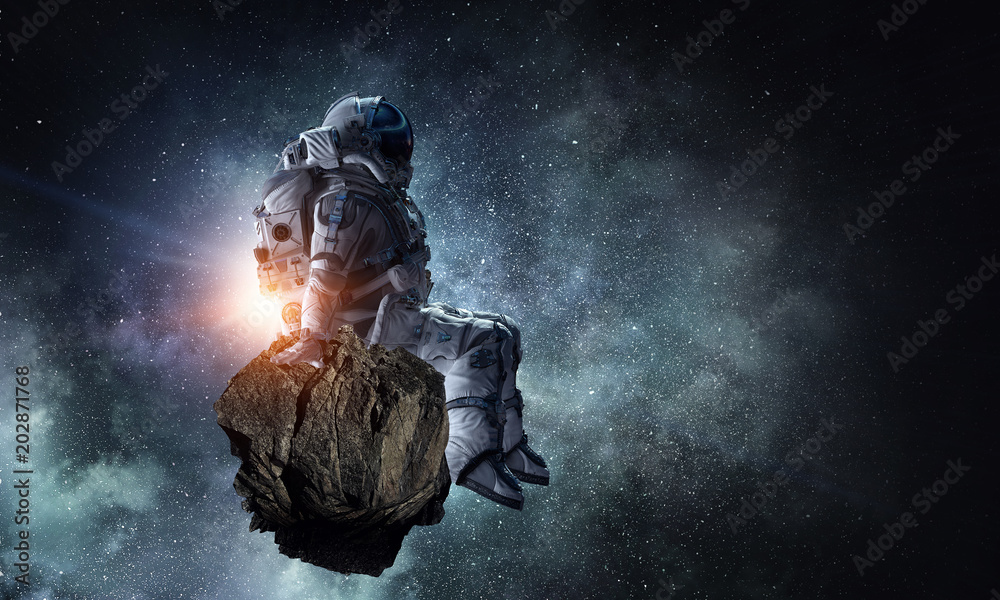 Fotografie Spaceman on rock edge. Mixed media