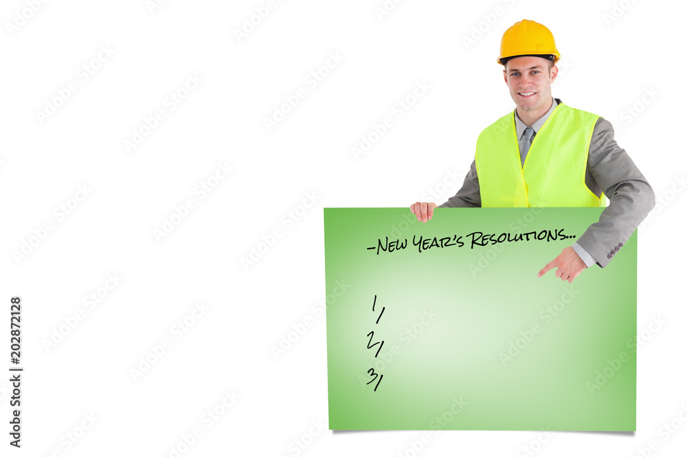 Smiling builder pointing at something against green card Smiling builder pointing at something against green card