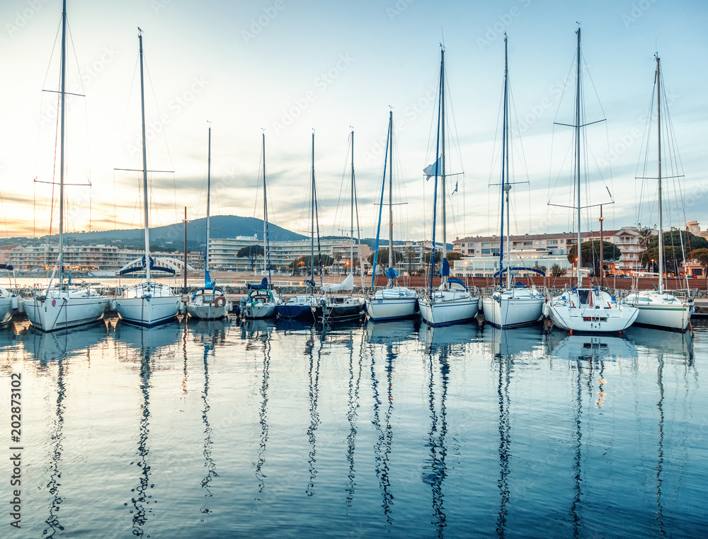 Seaport with boats and yachts on the Cote d'Azur in France at sunset, beautiful sea and city landscape