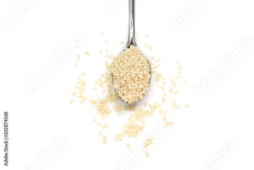 White sesame in a spoon on white background - isolated
