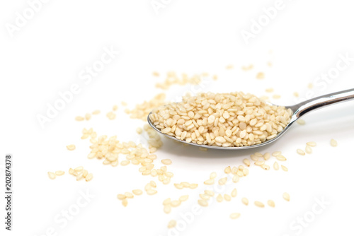 White sesame in a spoon on white background - isolated