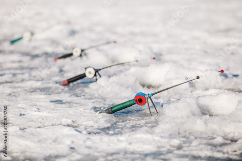 fishman puts the fishing rods on the ice of the river in the winter