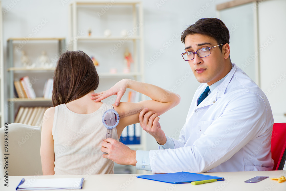 Doctor checking patients joint flexibility with gonimeter Doctor checking patients joint flexibility with gonimeter