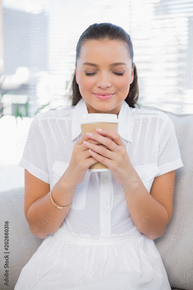 Relaxed pretty woman having coffee sitting on cosy couch Relaxed pretty woman having coffee sitting on cosy couch
