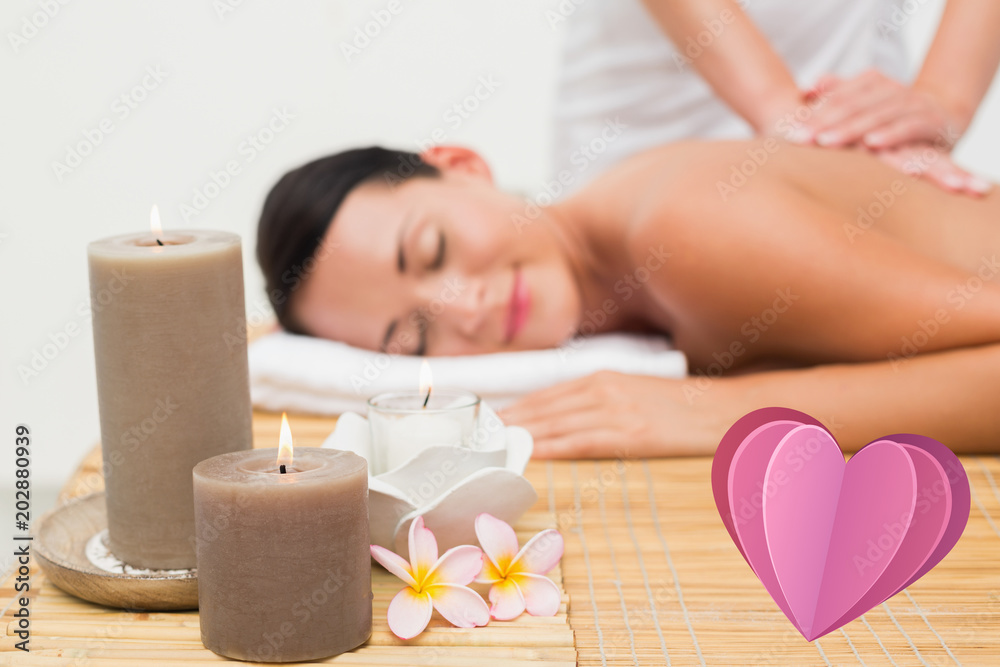 Beautiful brunette enjoying a back massage against heart Beautiful brunette enjoying a back massage against heart