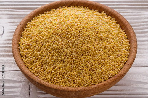 bowl of millet on a white wooden background